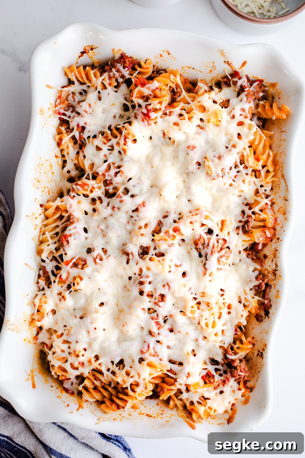 Cheesy Ground Beef Pasta Bake 2 A casserole dish filled with pasta and topped with cheese.