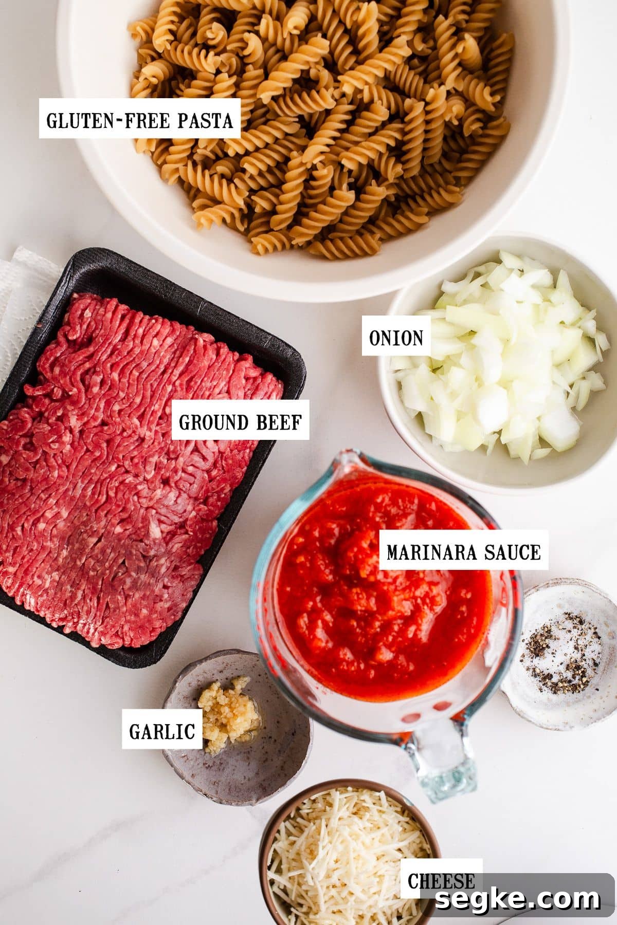 Cheesy Ground Beef Pasta Bake 3 Ingredients to make beef pasta bake on a marble surface.