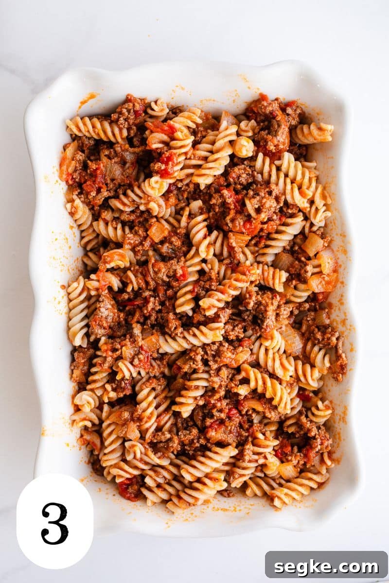 Cheesy Ground Beef Pasta Bake 6 Pasta and sauce in a casserole dish.