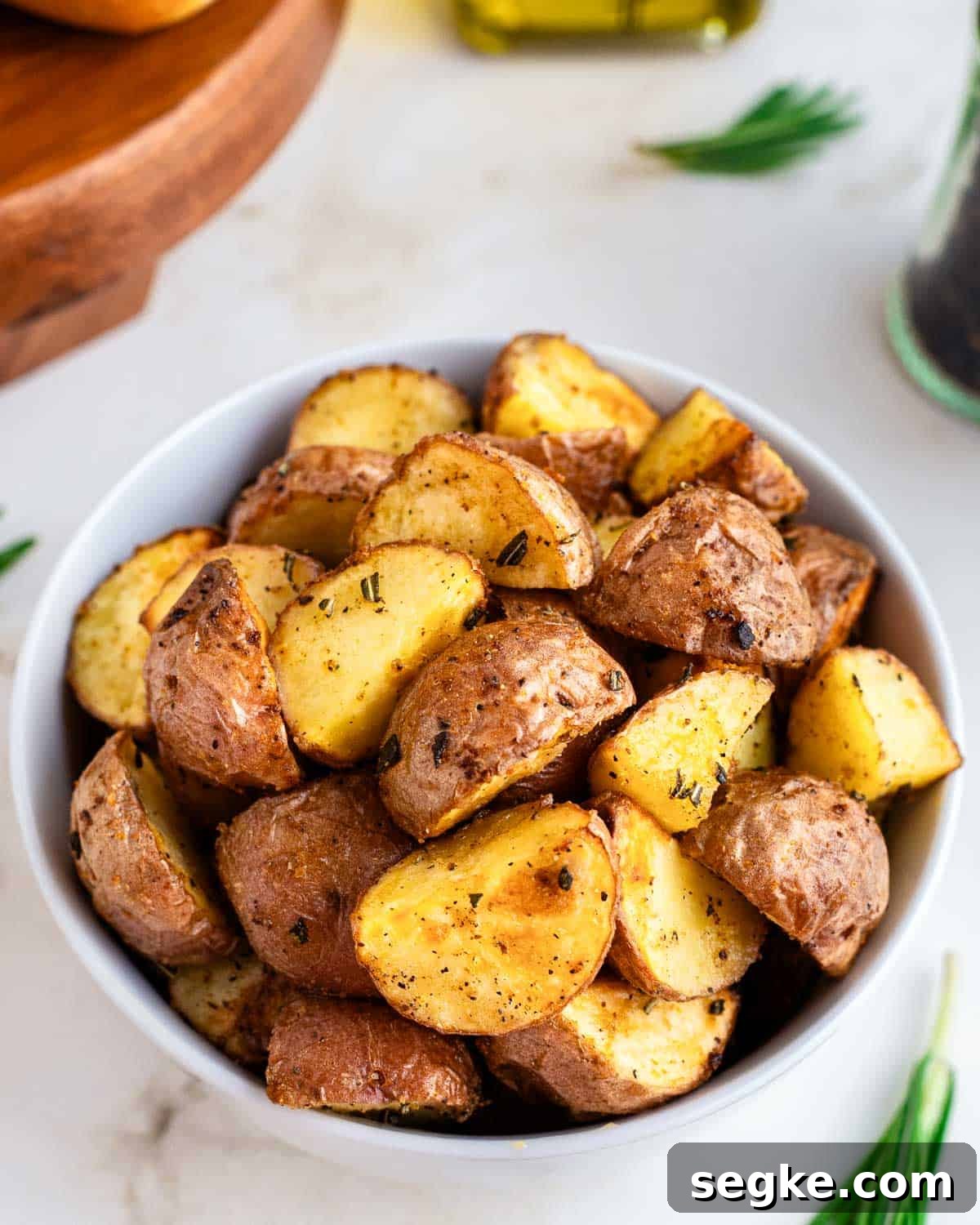 Perfectly Crispy Air Fryer Red Potatoes 6 Close up of air fryer roasted red potatoes in a white bowl.