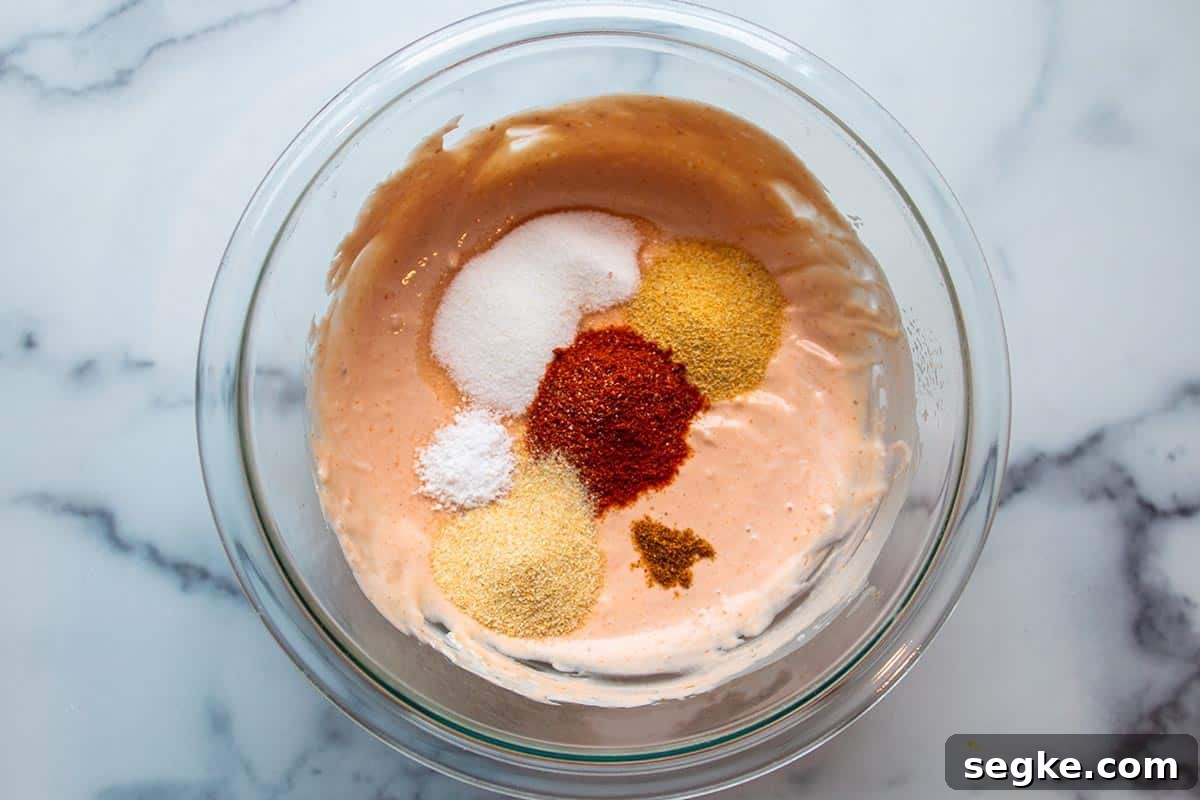 Glass Bowl with mayo and ketchup mix and spices on top.