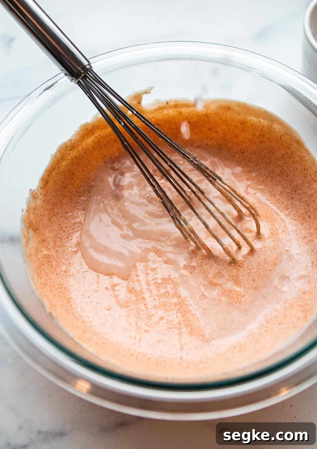 Glass bowl and whisk with finished yum yum sauce. 
