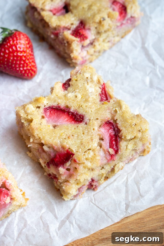 Sliced strawberries and orange zest on a board