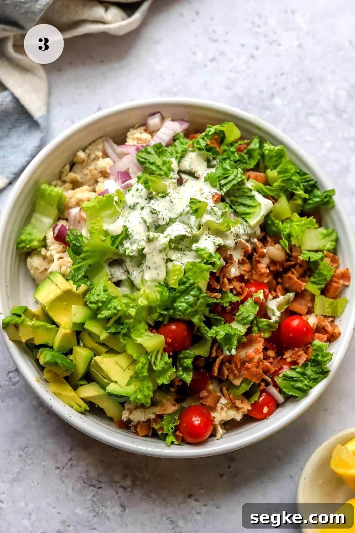 White bowl with BLT chicken salad in it before it's mixed. 