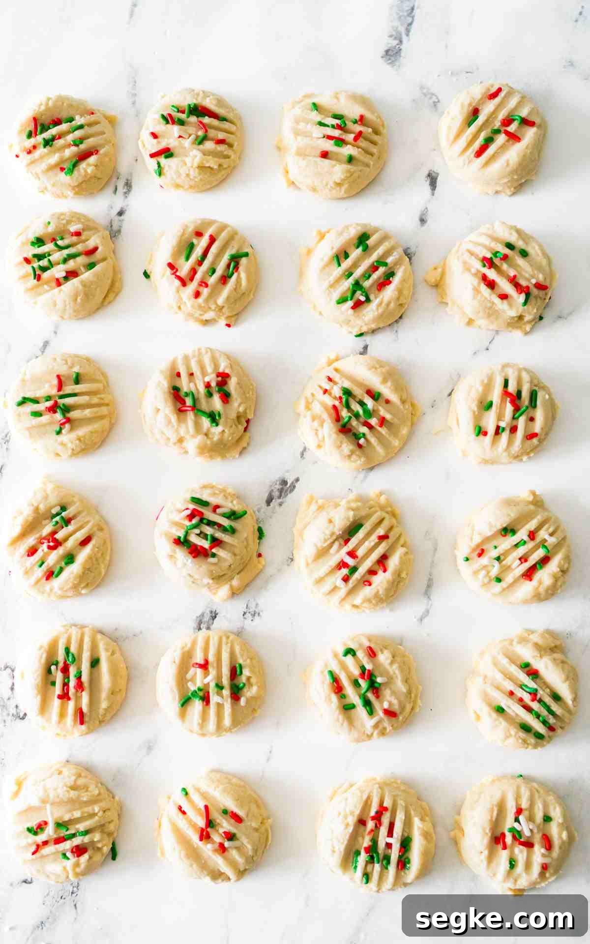 Light, Fluffy Whipped Shortbread Cookies Recipe 3 Whipped shortbread cookies with lines cut into it with sprinkles.