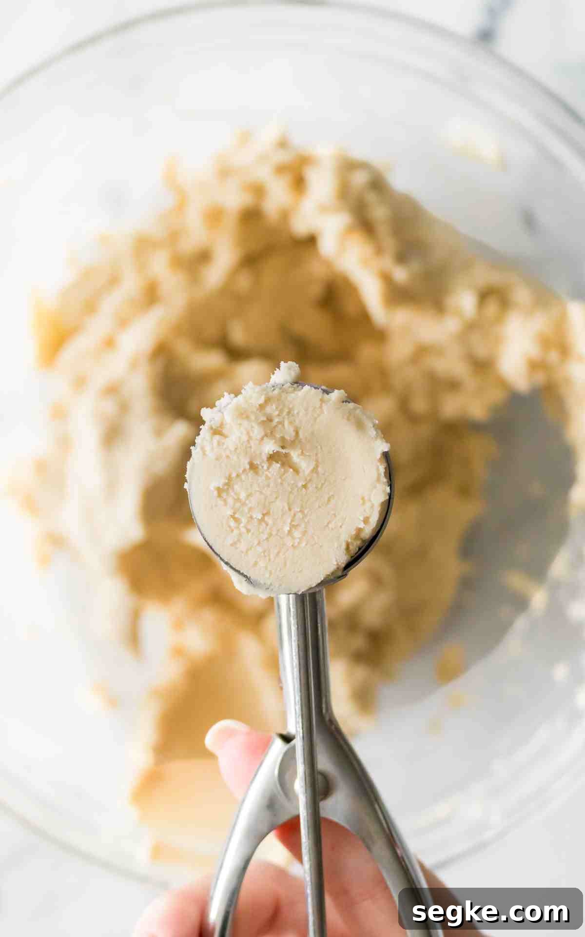 Light, Fluffy Whipped Shortbread Cookies Recipe 4 A cookie scoop filled with whipped shortbread cookie dough.