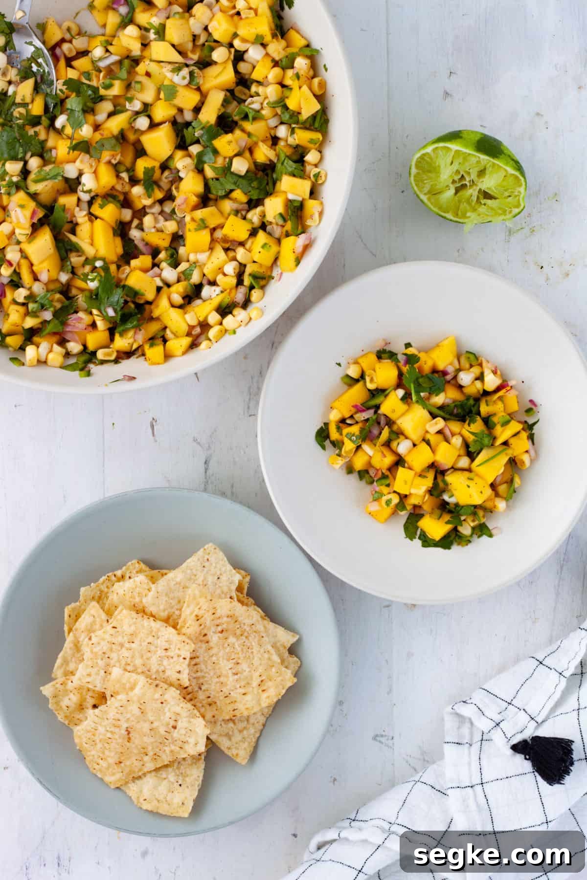 Mango and Corn Salsa in a large bowl with a smaller serving on the side and a small bowl of tortilla chips.