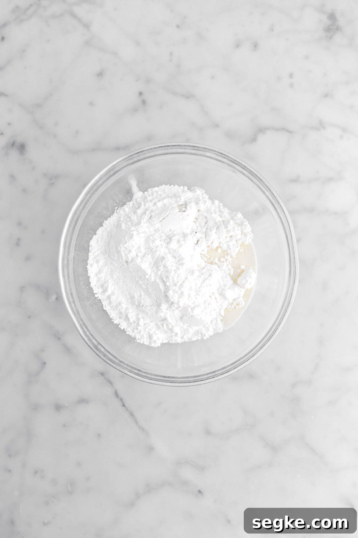 powdered sugar, milk, and vanilla in glass bowl.