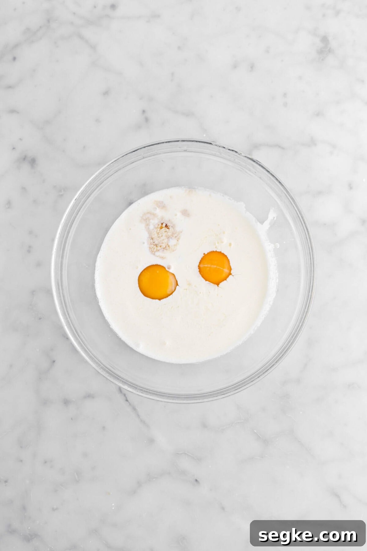 eggs, cream, and vanilla in glass bowl.
