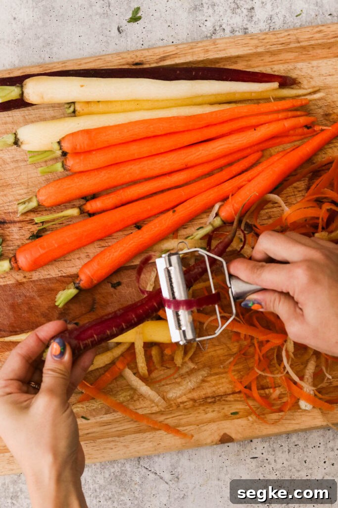 a hand peeling carrots with a veggie peeler 