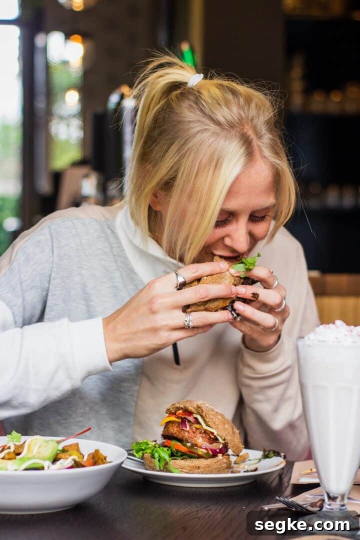 woman eating hamburger in a restaurant