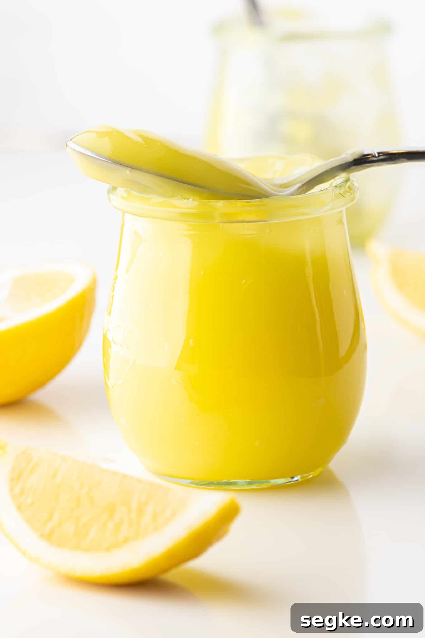 Quick Keto Lemon Curd Recipe: Zesty Low-Carb Spread 2 A jar of keto lemon curd with a filled spoon resting on top.