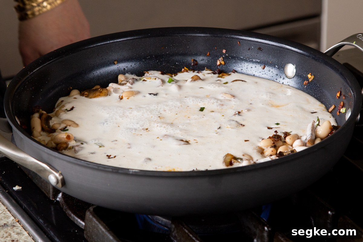 One-Pan Tuscan White Bean Skillet Recipe 11 cashew milk added to the pan of beans and veggies