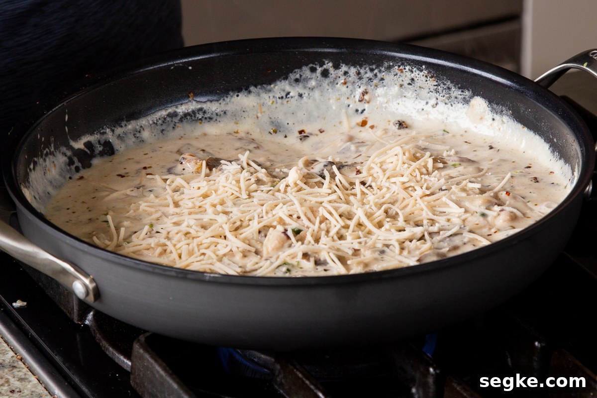 One-Pan Tuscan White Bean Skillet Recipe 12 vegan parmesan sprinkled onto the tuscan beans in the pan