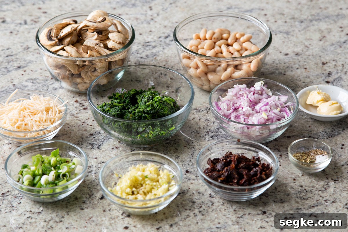 One-Pan Tuscan White Bean Skillet Recipe 4 white beans, veggies, and seasonings in bowls on a kitchen counter