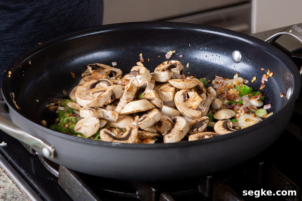 One-Pan Tuscan White Bean Skillet Recipe 8 adding mushrooms to the frying pan