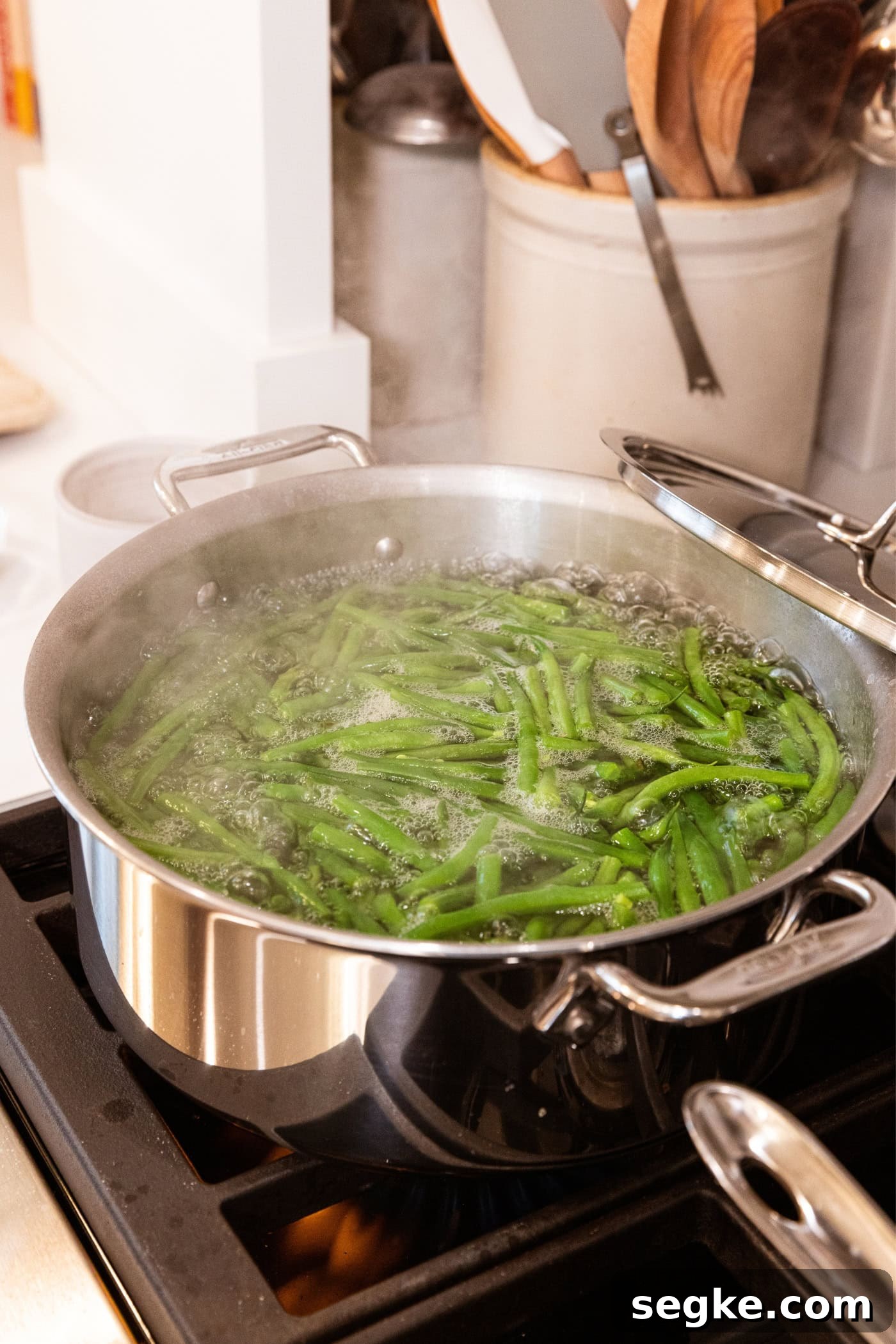 Creamy Homemade Green Bean Casserole Recipe 6 Stainless steel pot on the stovetop filled with blanching green beans in boiling water.