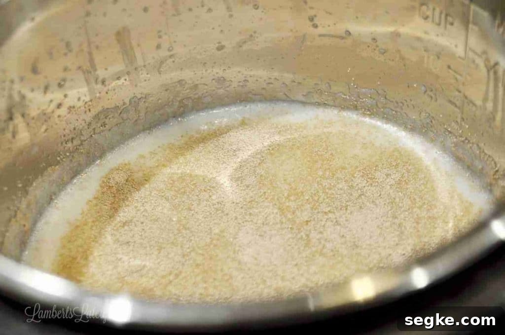 Close-up of a mixture in a mixing bowl for cinnamon rolls with cream cheese frosting.