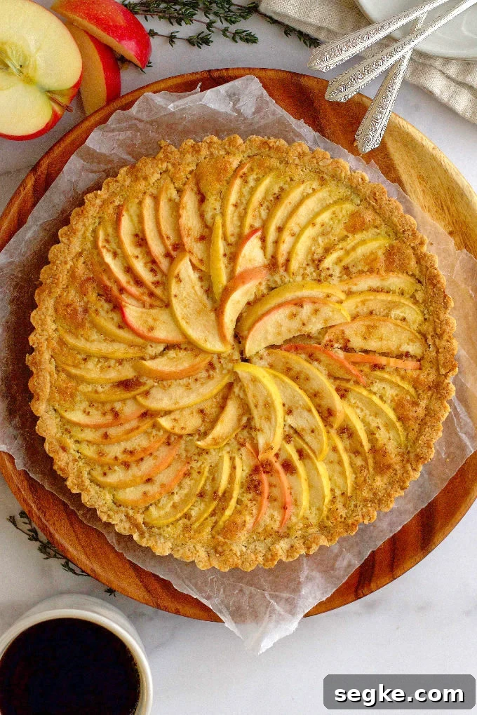 baked apple frangipane tart on a wood plate