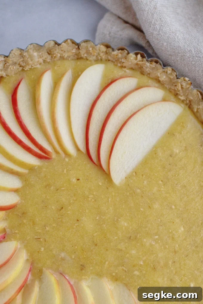apple slices being fanned on top of Frangipane filling