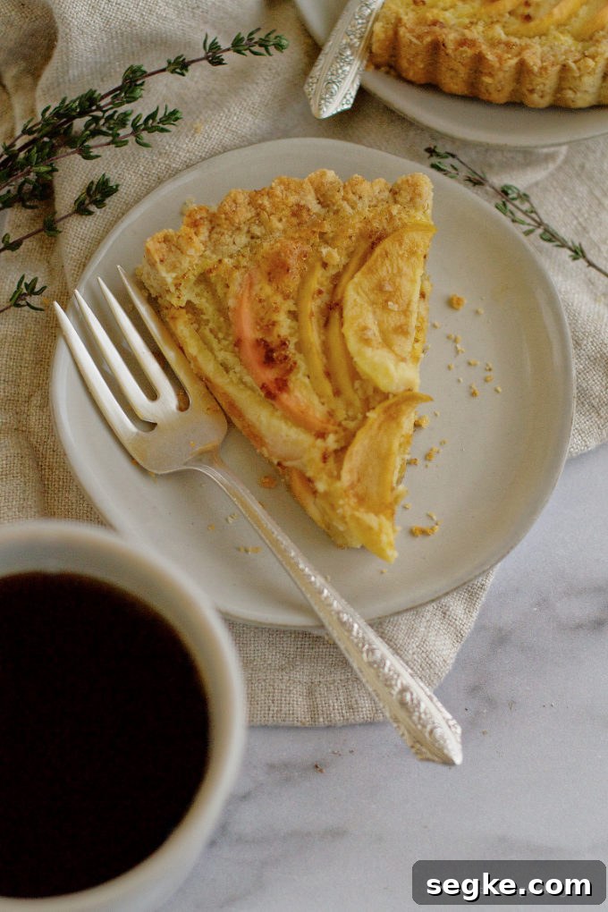 a slice of frangipane tart on a plate with a fork
