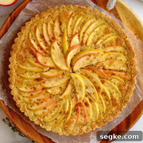 baked apple frangipane tart on a wood plate