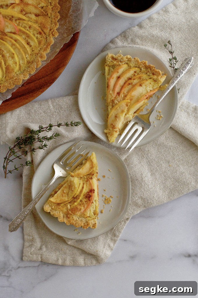 two slices of apple tart on plates with forks