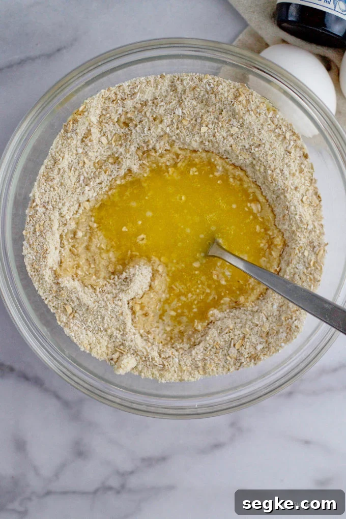 melted butter being mixed into almond and oat flours