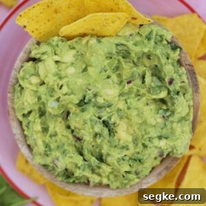 A bowl of gluten free guacamole with tortilla chips.