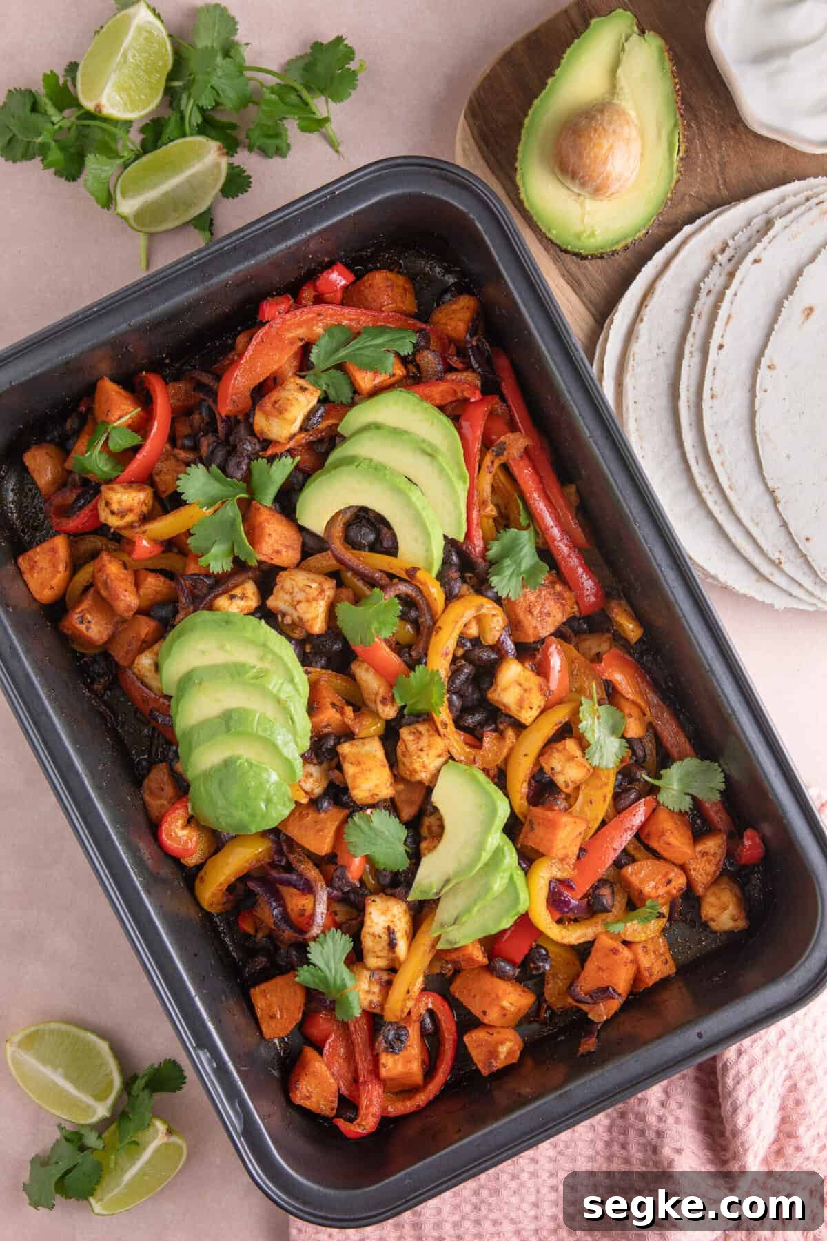 Sheet Pan Halloumi Tacos with Roasted Vegetables 2 Overhead shot of halloumi taco fillings in a baking tray, with sweet potato, black beans and peppers.
