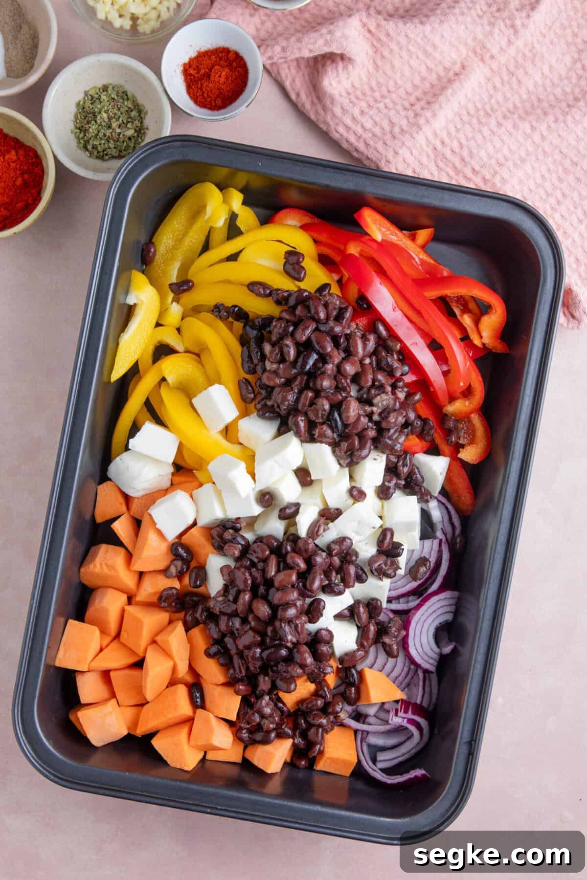Sheet Pan Halloumi Tacos with Roasted Vegetables 4 Process shot for halloumi tacos recipe showing all the ingredients added to a pan, including halloumi, peppers, onion, sweet potatoes and black beans.