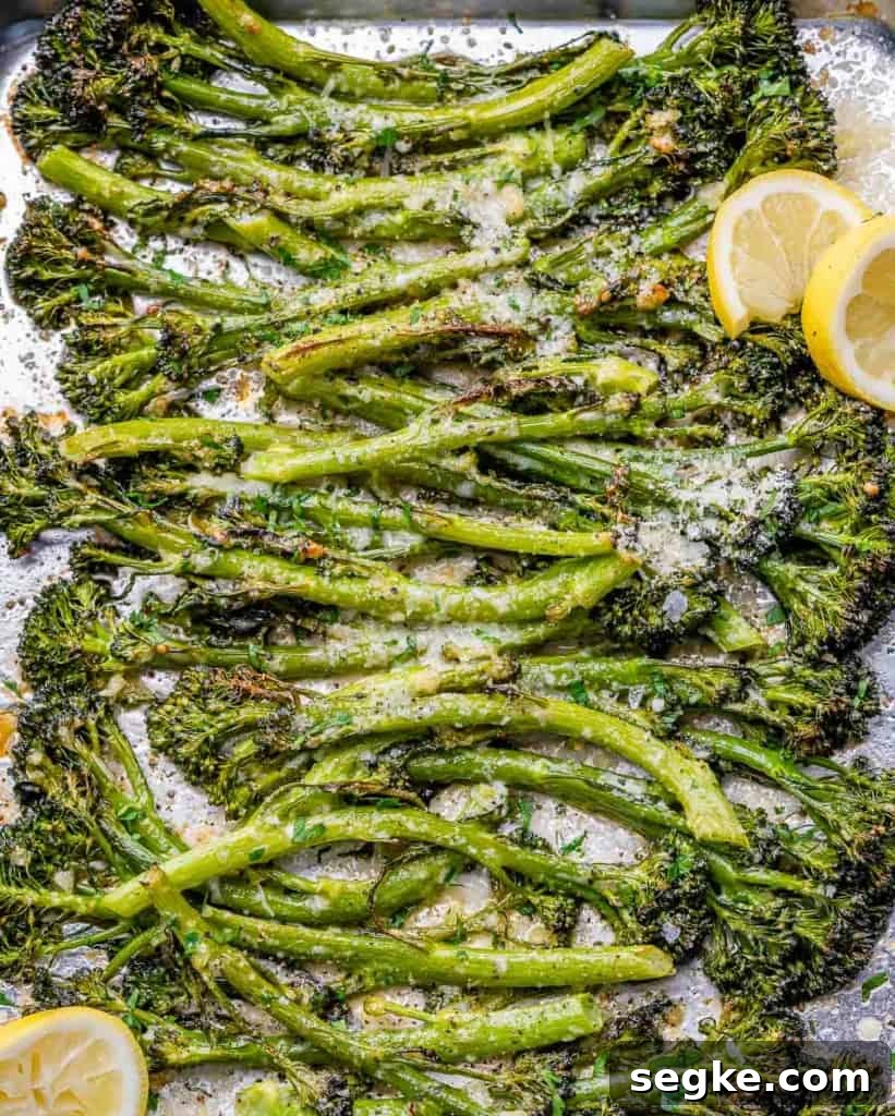 top view roasted broccolini on a pan with a few lemon granishes 
