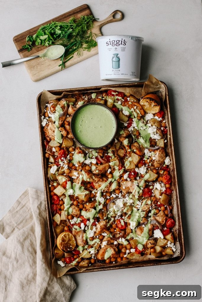 chicken and veggies on sheet pan with green yogurt sauce 