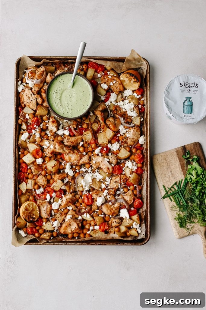chicken and veggies on sheet pan with green yogurt sauce 