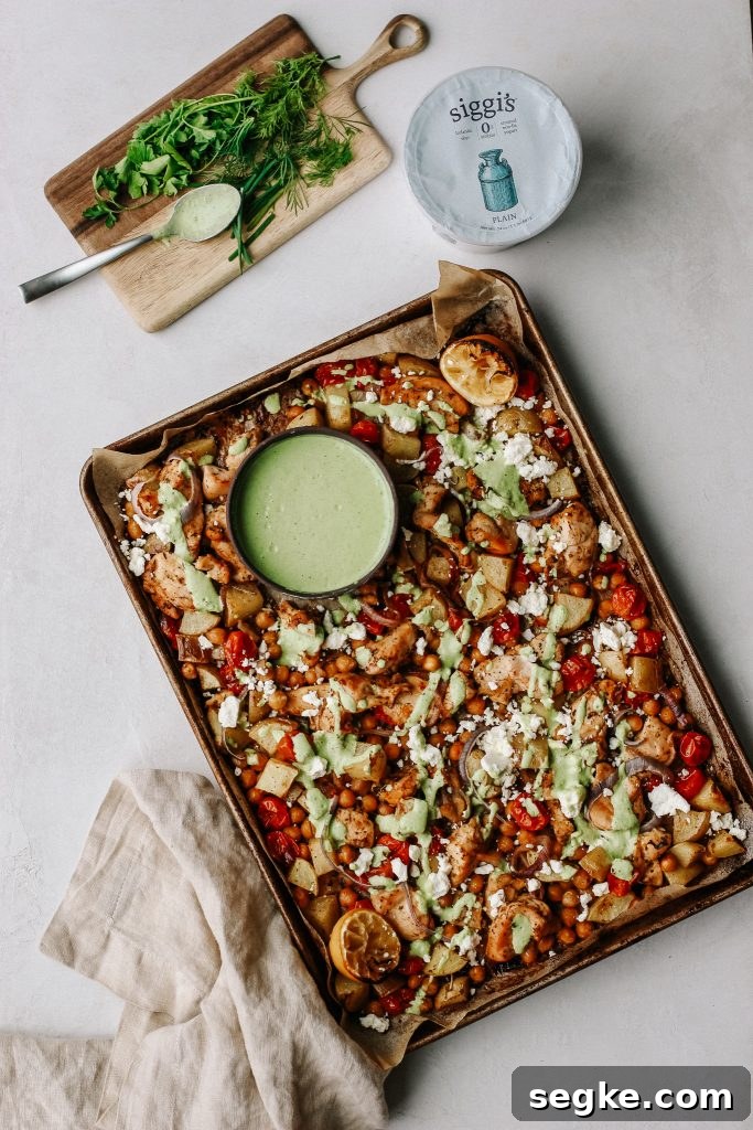 chicken and veggies on sheet pan with green yogurt sauce 