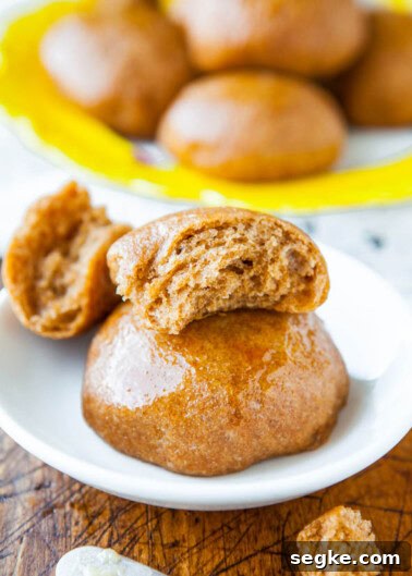 Glazed gingerbread spice donuts with one split open to show the inside.
