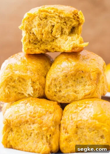 A stack of golden-brown pumpkin biscuits on a white plate.
