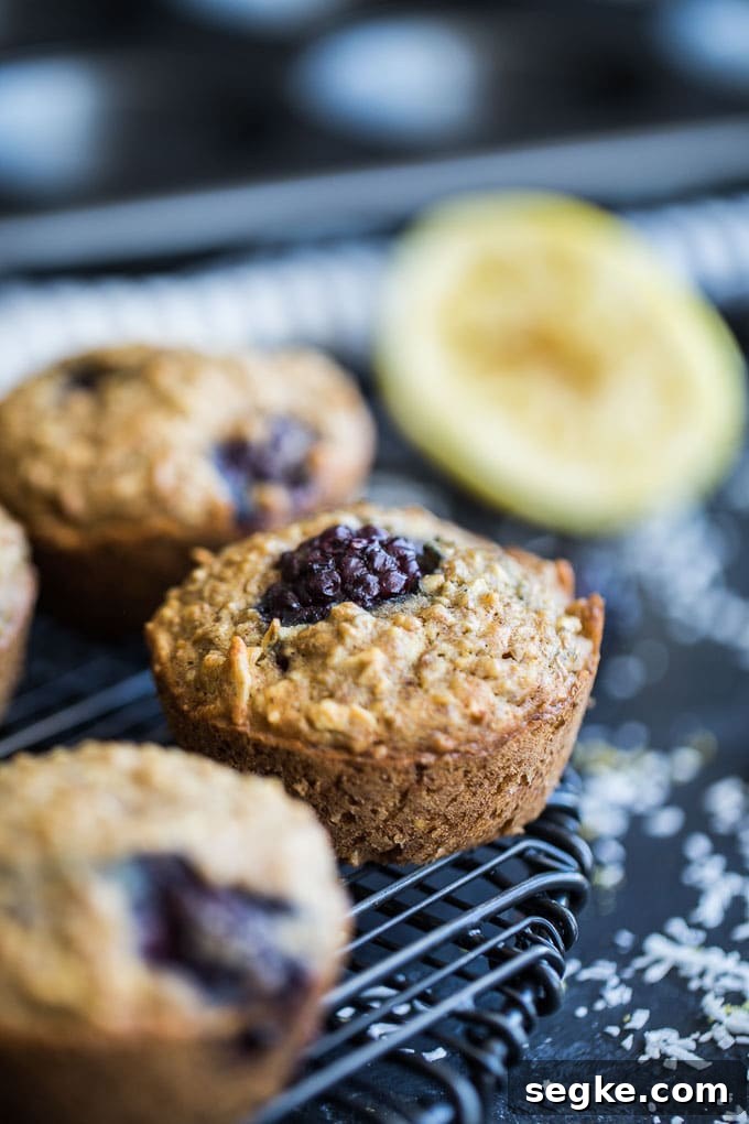 Up-close side view of Blackberry Lemon Overnight Oatmeal Muffins cooling on a wire rack.