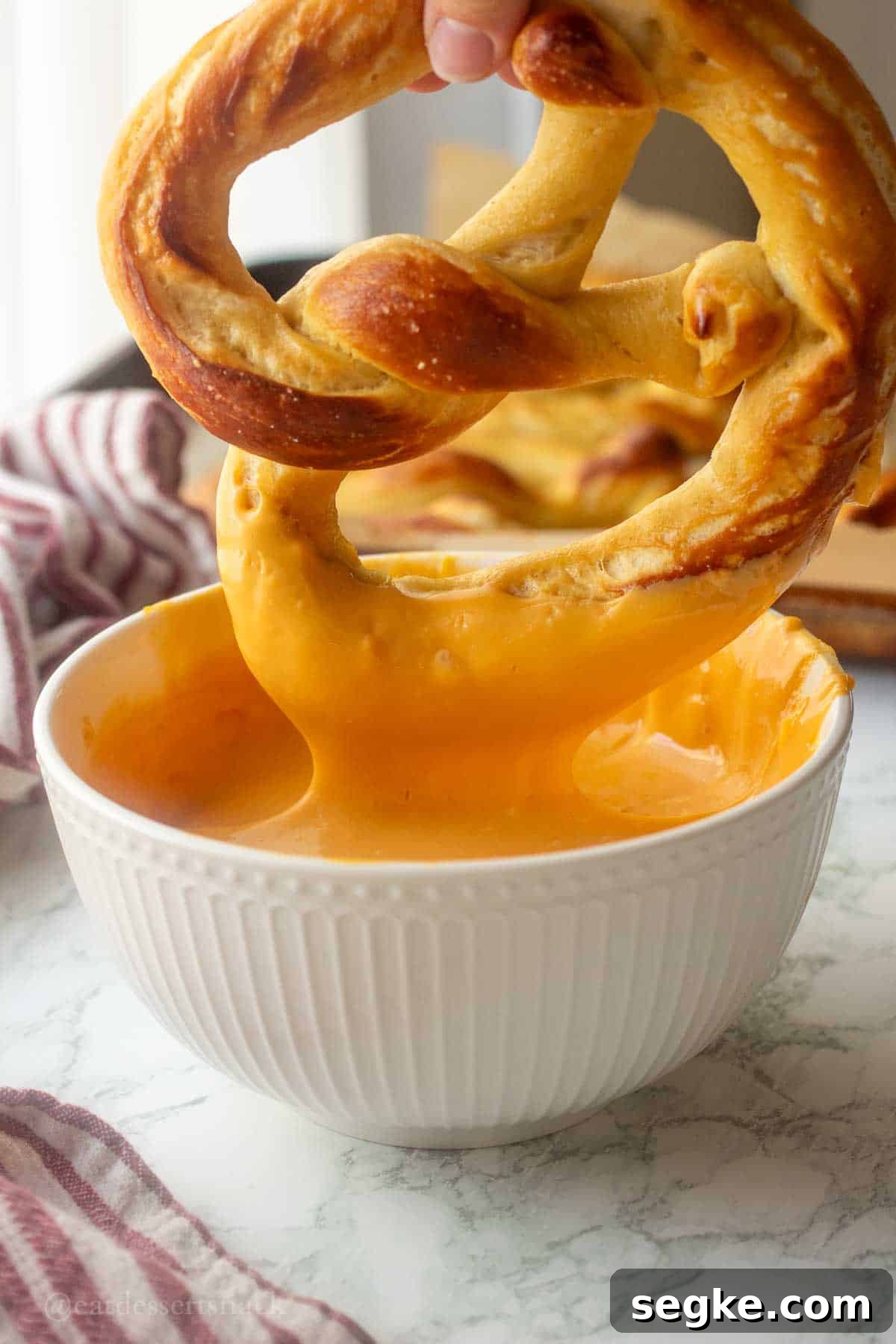Homemade Soft Baked Amish Pretzels Recipe 8 Baked pretzel dipping in cheese dip.