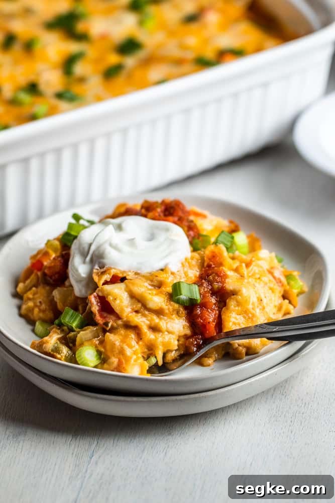 Creamy King Ranch Chicken Casserole Recipe 7 Slice of ranch casserole on a white plate with dish in the background.