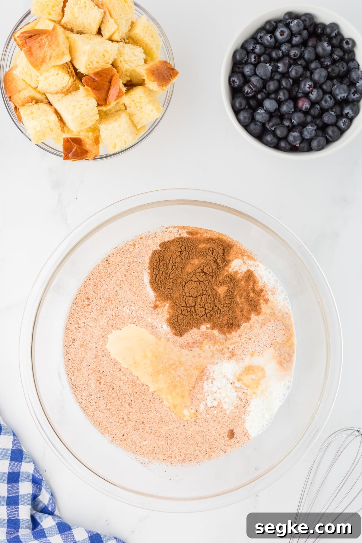 A bowl filled with half and half, eggs, cinnamon, brown sugar.