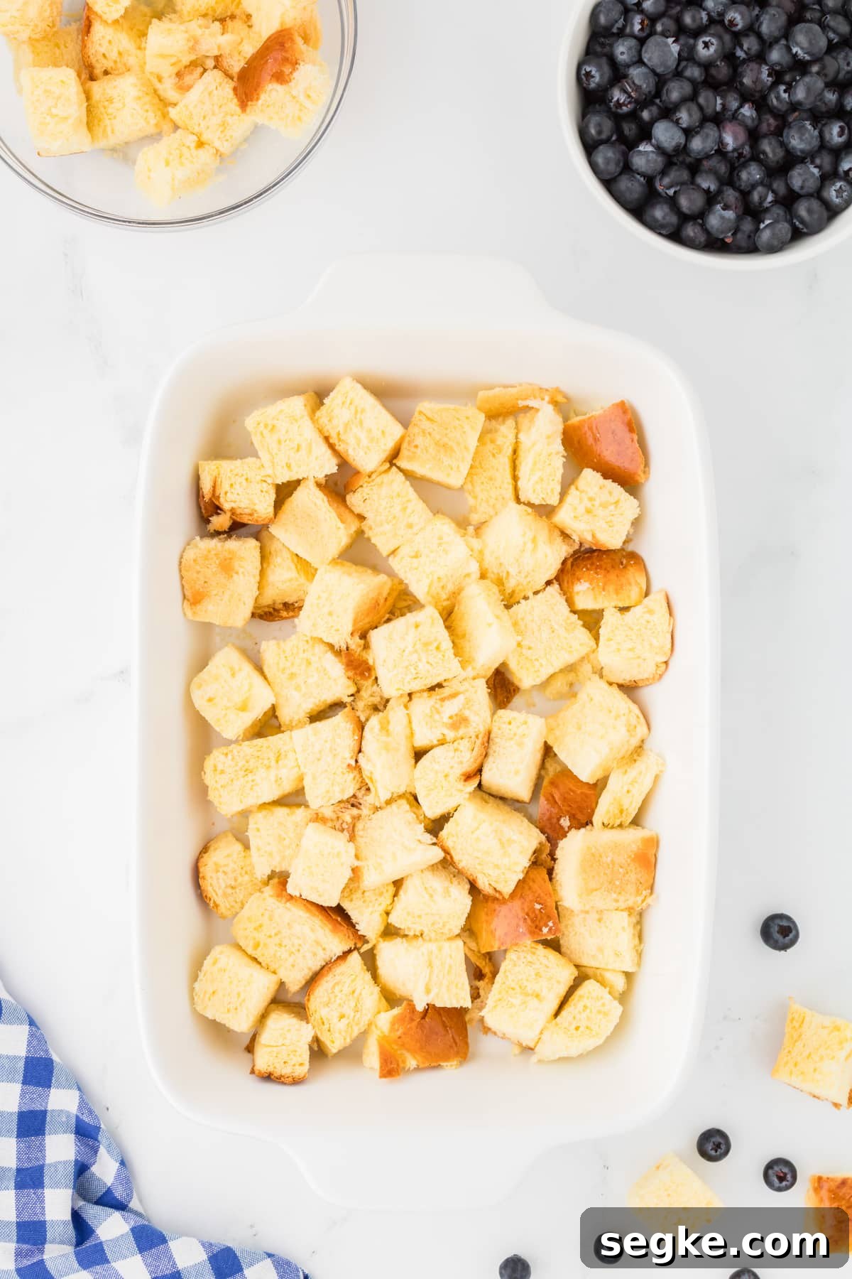 A baking dish with cubed bread in it.