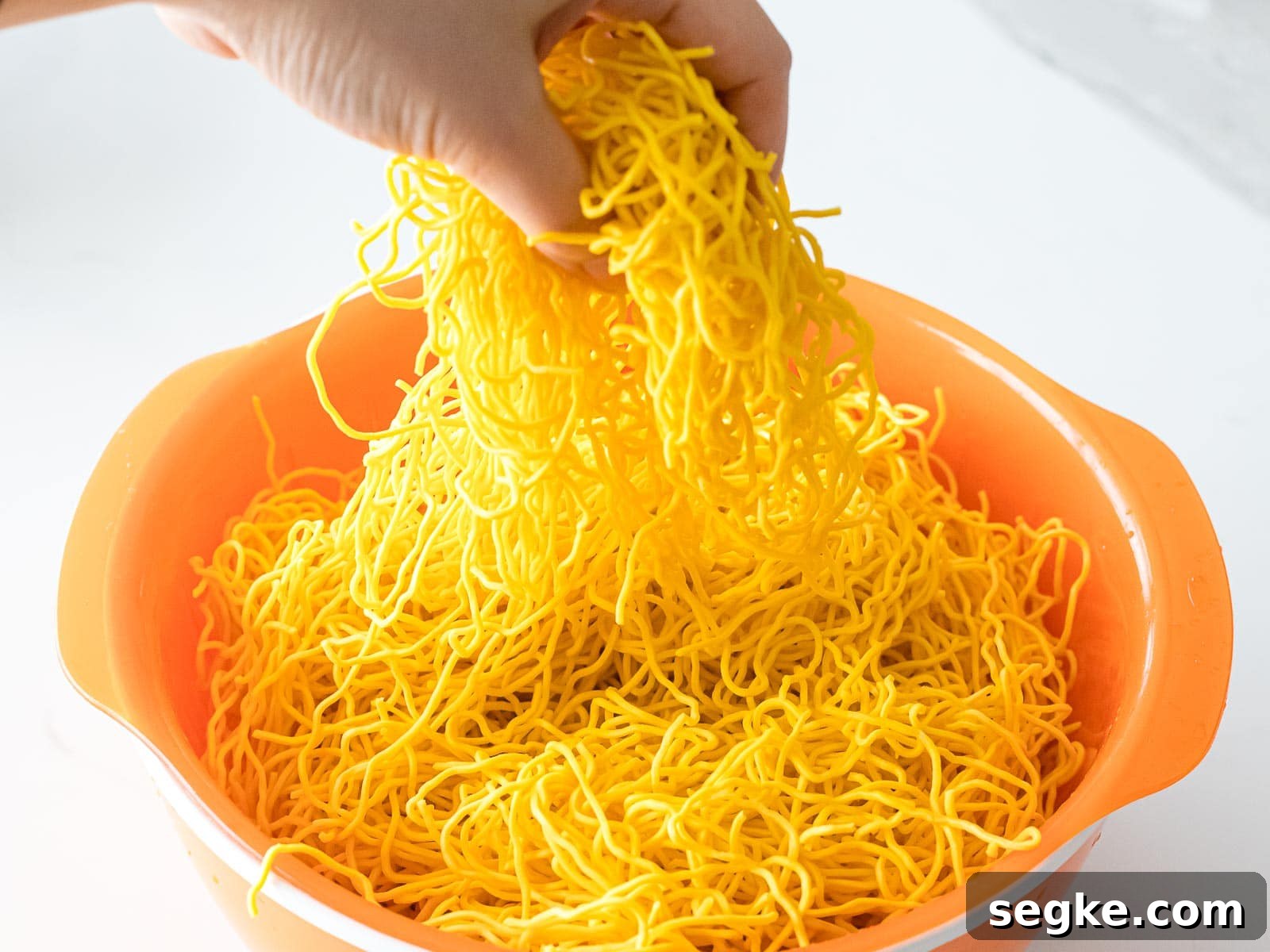 Chinese chow mein noodles in an orange bowl