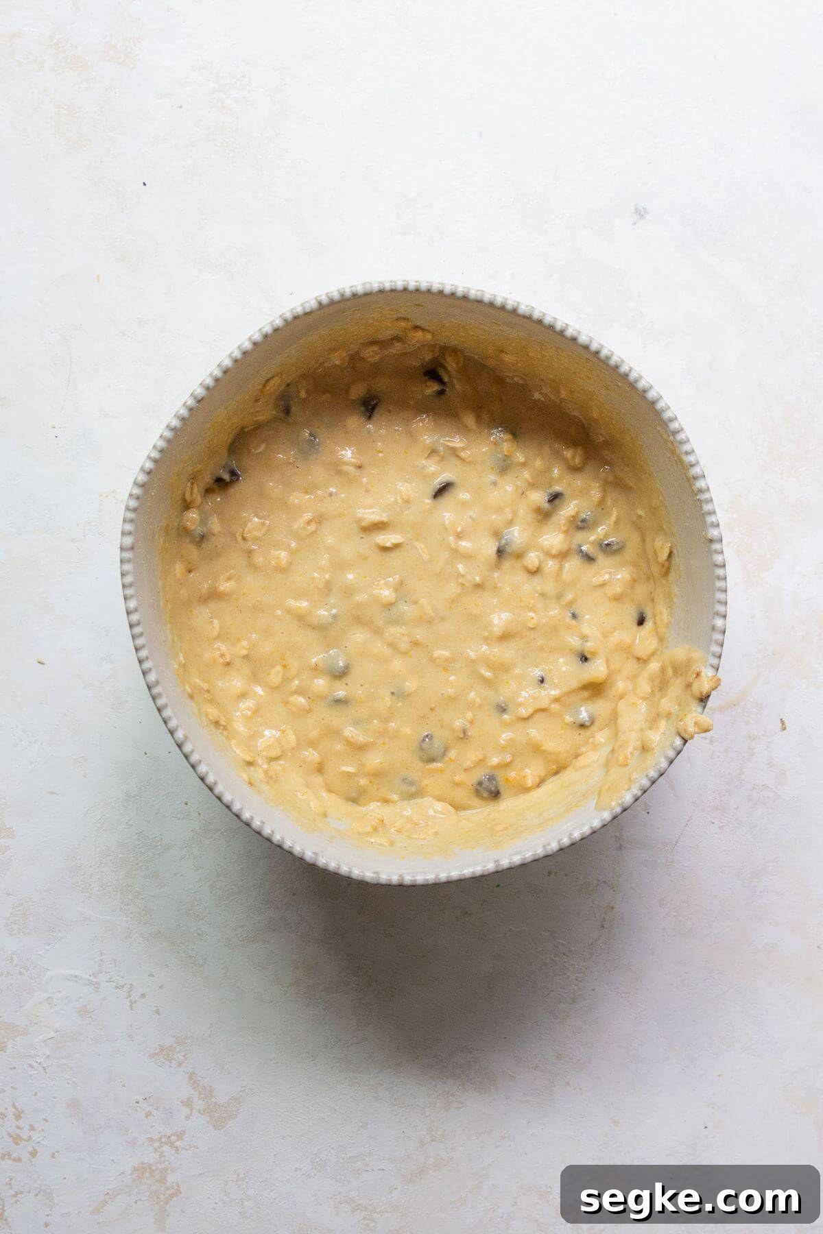 Chocolate chip oatmeal muffin batter mixed until just combined in a large bowl.