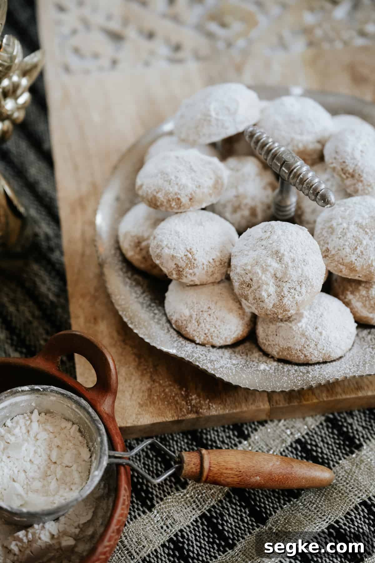 Polvorones Cookies (Mexican Wedding Cookies) on a vintage silver tray with powdered sugar bowl on the side.