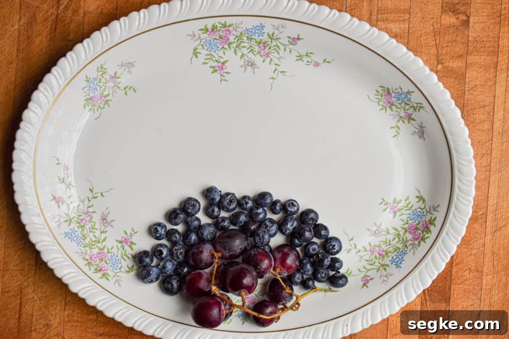 The blueberries are added to the platter with the grapes.