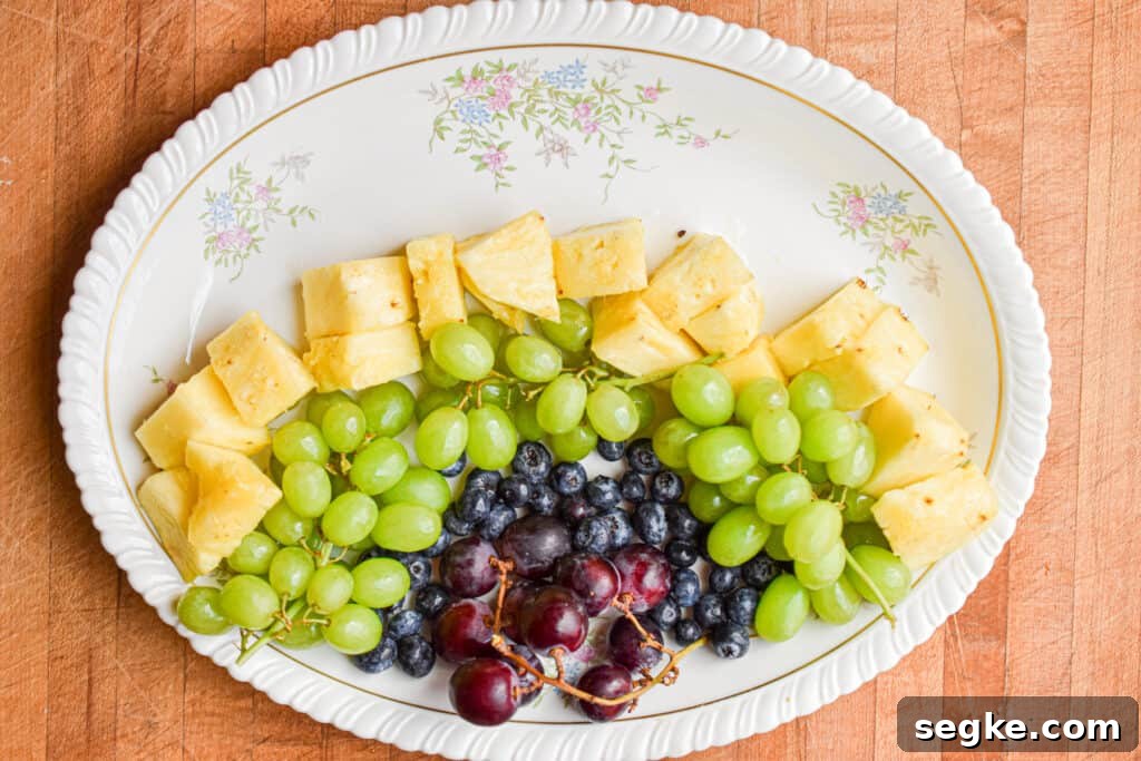 Pineapple is added to the platter with the rest of the fruit.