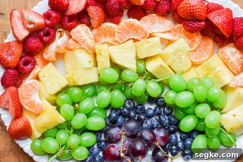 The full fruit rainbow is laid out on an oval platter.