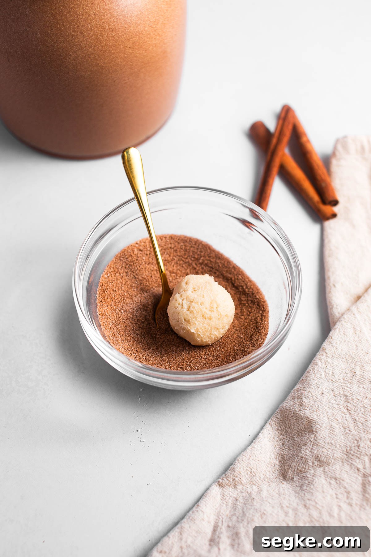 Rolling cookie balls in cinnamon sugar