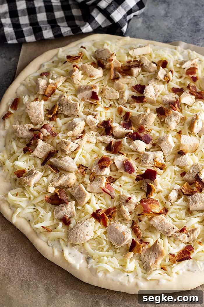 Crispy Chicken Bacon Ranch Pizza Recipe 4 Pizza topped with all the toppings and ready for the oven.